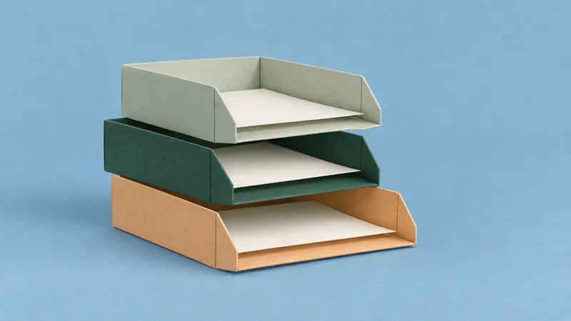 Three stepped paper document trays in apricot, green, and sage hold ivory sheets against a sky-blue background.